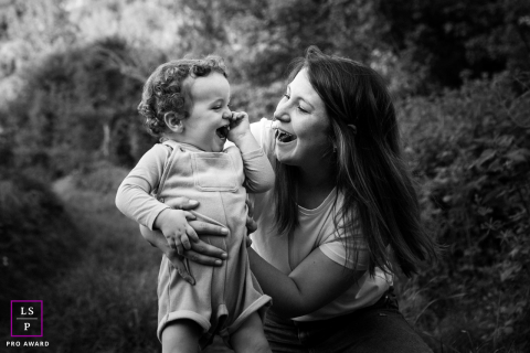La connexion sincère entre une mère et son fils dans un portrait noir et blanc de Haute-Garonne Une image en noir et blanc capturant le lien entre une mère et son fils, partageant une séance joyeuse dans la nature en Haute-Garonne.