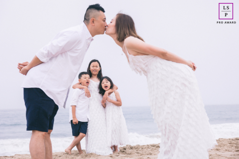 In Boston, Massachusetts, a toddler is the center of attention, lovingly framed by the out-of-focus profiles of their parents in the foreground.
