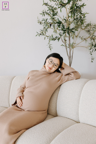 In Chicago, IL, an expectant mother poses peacefully on the couch at home, awaiting her baby's arrival. The serene atmosphere reflects their anticipation and harmony in this special time.