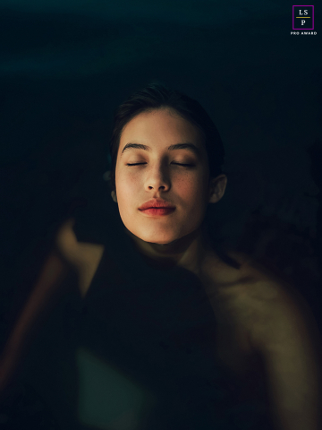 Emerging Serenity: A Woman's Tranquil Swim in Ottawa River's Calm Embrace In Ottawa, Ontario, a woman swims in the Ottawa River, her face emerging from the calm, still water against a dark background. The serene scene captures her peaceful connection with nature.