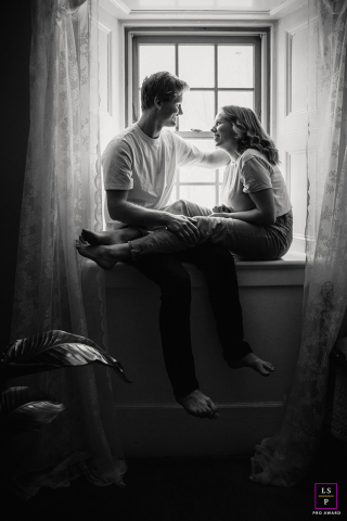 Warmth and Light: A Couple's Serene Connection on Braeside's Window Bench In Braeside, Ontario, Canada, a couple sits on a window bench enveloped by soft window light. The scene captures their peaceful connection and the warmth of the intimate setting.