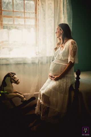 Expectant Dreams: A Mother's Hopeful Gaze in Ottawa's Windowed Serenity In Ottawa, Ontario, Canada, a pregnant woman sits by the window, gazing out as she envisions a beautiful future. The scene captures her serene anticipation and hopefulness.