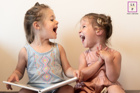 À Solliès, dans le Var, en France, deux petites filles partagent d'adorables rires tout en étant assises et en lisant un livre ensemble.