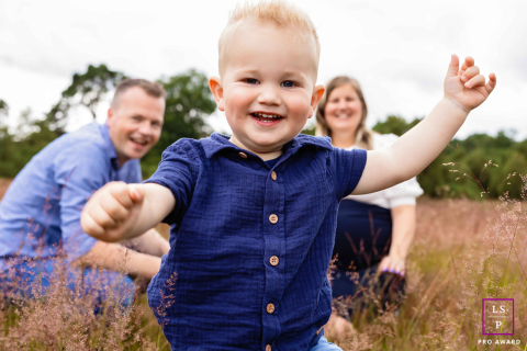 Un enfant heureux court vers le photographe à Overijssel, aux Pays-Bas. Les bras tendus, il arbore un large sourire, empli de joie et d'enthousiasme.