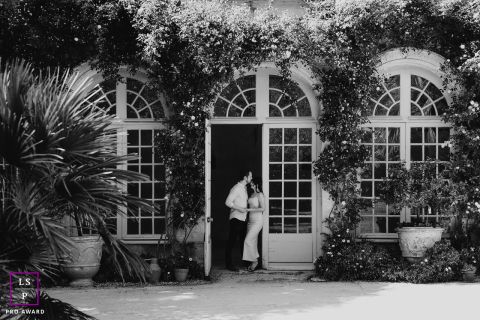 Encadré par la grandeur : la romance intime d'un couple de châteaux en pierre Au Château de Flaugergues, un couple se fait face sous un portail majestueux, encadré par une architecture romantique. Le cadre élégant renforce l'atmosphère intime de leur séance photo.