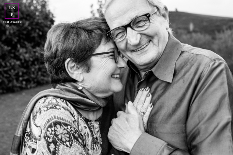 In La Bastide-Clairence, a mature couple is captured in a black and white, tight close-up. Their faces beam with warmth and happiness, highlighting their deep connection and joyful expressions.