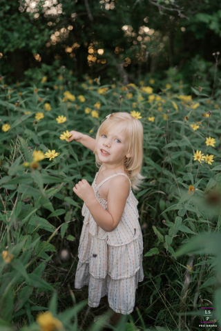 A West Bend Girl's Loving Gift: Hand-picked Flowers Amid Lush Wisconsin Greenery In West Bend, Wisconsin, a young girl holds flowers she picked for her mom, captured in a vertical shot amid lush foliage.