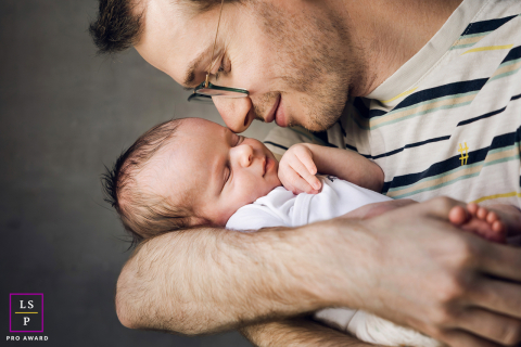 In Lyon, France, a close-up portrait shows a dad face to face with his baby, capturing their intimate connection.