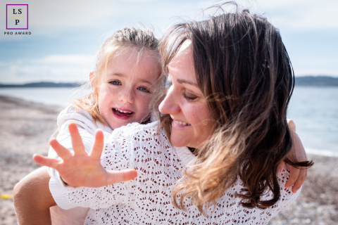 At L'Almanarre on the Giens Peninsula in Var, France, a mother and daughter play together on the beach, sharing smiles in the sand and surf.