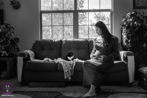 In Los Angeles, an expectant mother finds gentle companionship in her cat as they wait together for the new arrival.