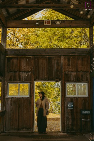 In Ithaca, New York, a woman stands in a doorway, poised between shadow and golden light, capturing a quiet sense of transition and new beginnings.