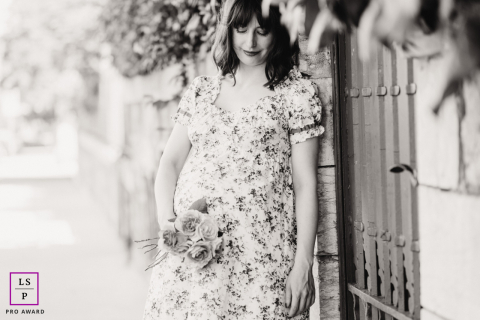 A pregnant woman smiles, walking gracefully in the historic streets of Geneva, her favorite city.