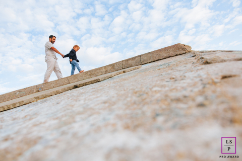 Father and young son walking hand-in-hand together in Tarnos, Landes, France, in a natural setting.