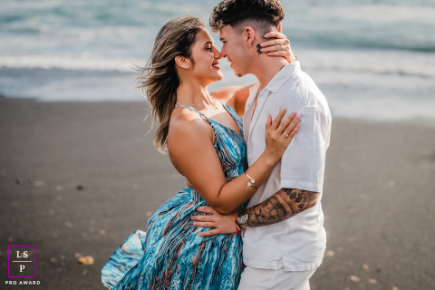 Romantic couple on a Lanzarote beach, standing closely and intimately gazing into each other's eyes.