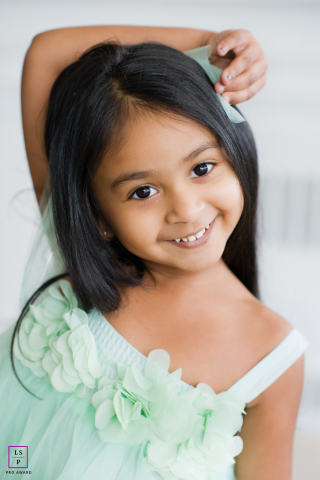 Playful toddler with an authentic, joyful smile looking directly into the camera on Long Island, NY.