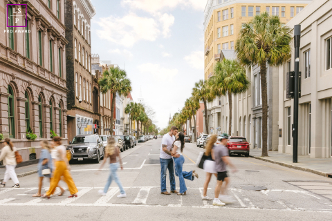 In Charleston, South Carolina, the couple pauses for a kiss in the middle of the crosswalk while the city rushes past around them. The motion blur and centered composition create a portrait filled with romance, energy, and cinematic stillness.