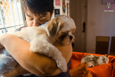 Um fotógrafo de estilo de vida de animais de estimação em São Paulo, Brasil, capturou a foto de um cachorro muito relaxado sendo abraçado por seu dono dentro de sua casa durante a sessão de retratos.