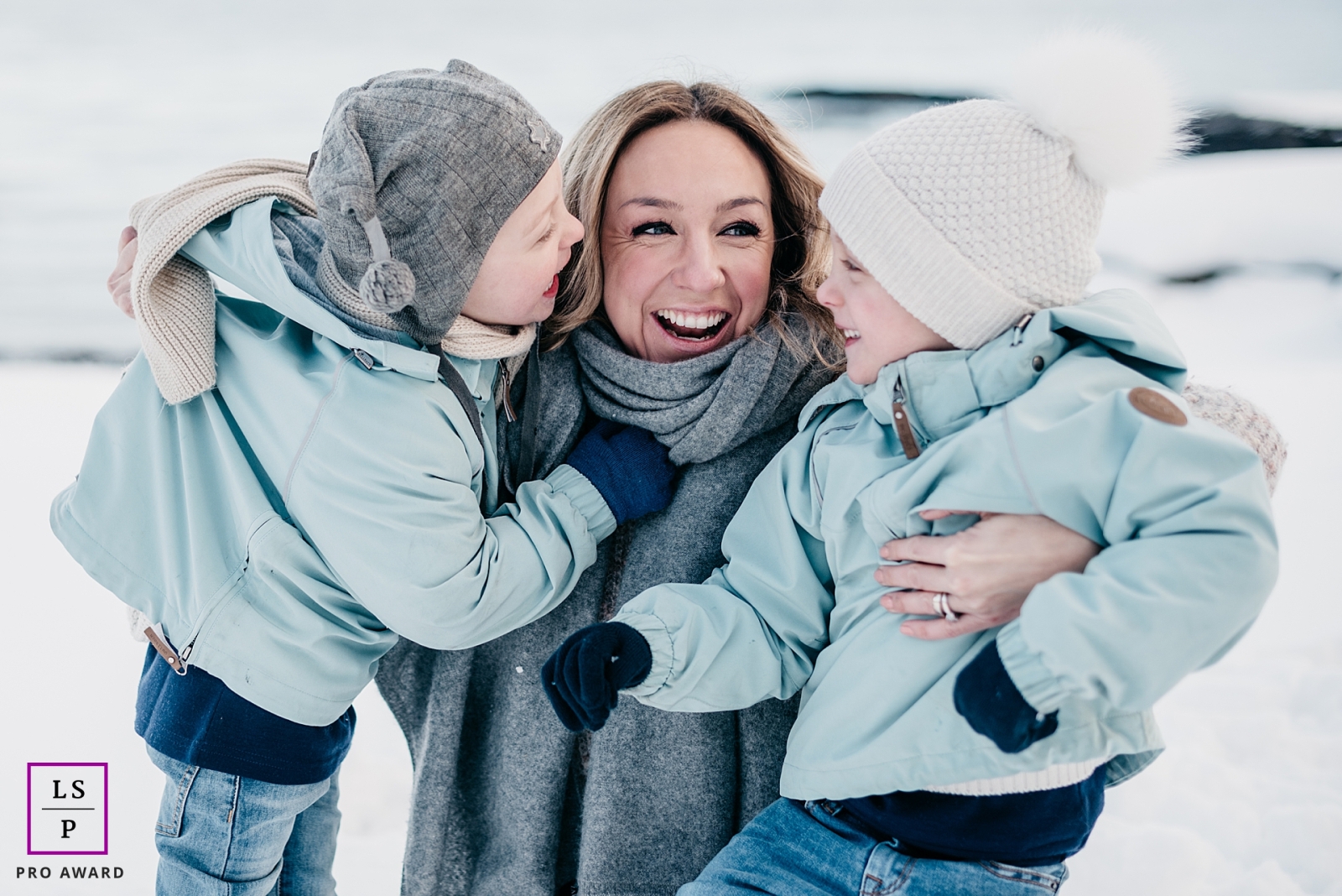 A modern Oslo lifestyle photography session that documented in Norway a Mom and twin sons enjoying time together outdoors in the winter snow with jackets on