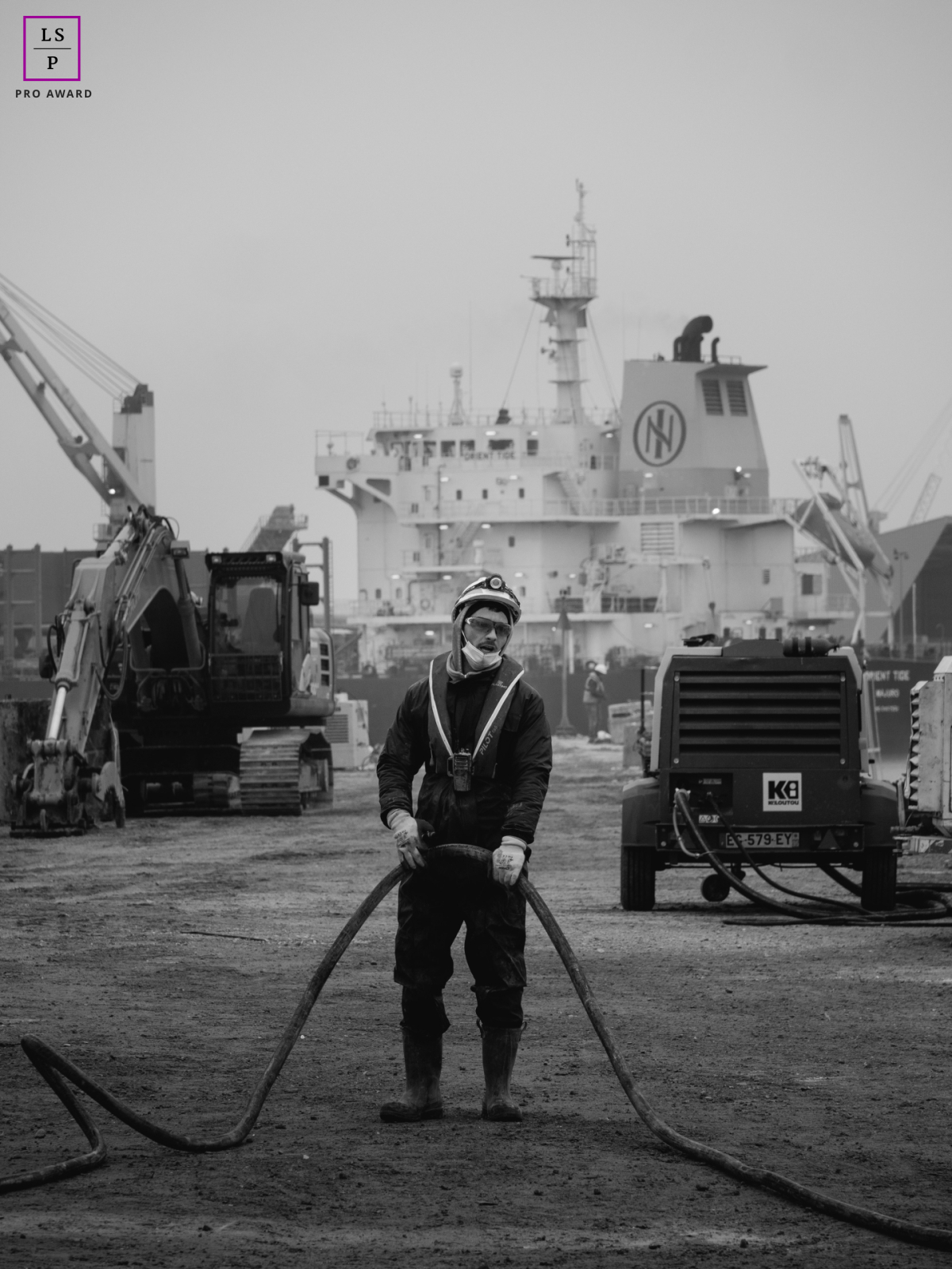 Un ouvrier du bâtiment de Charente Maritime, coiffé d'un casque de chantier, s'accroche avec détermination à une ligne électrique. Cette image puissante traduit le savoir-faire et le professionnalisme de Spie Batignolles Fondations.