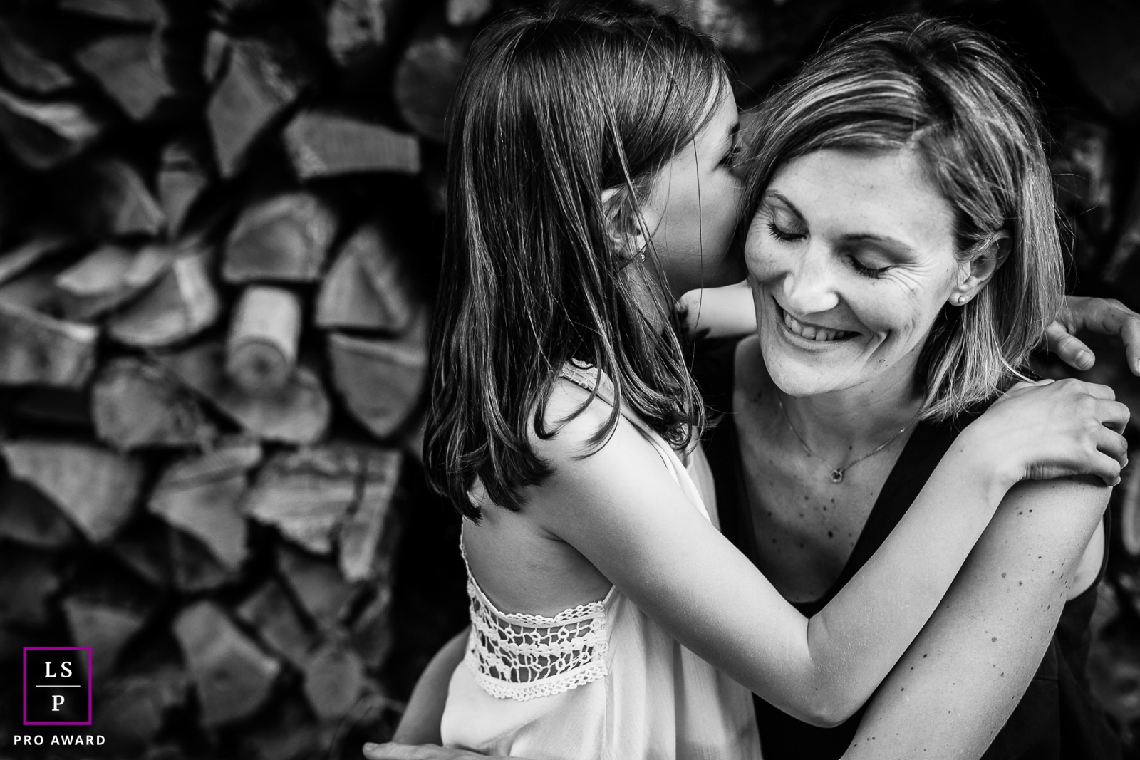 Family Photographer in Bourgogne-Franche-Comte France | Lifestyle Image contains: mother, daugther, wood pile, black and white