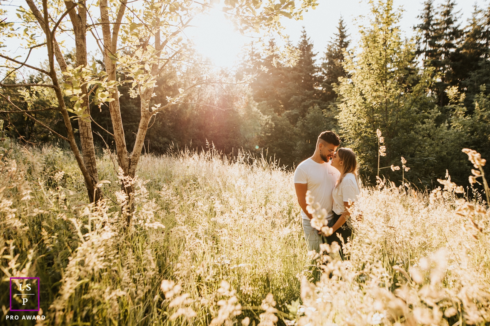 Rhone couple portrait session for a France lifestyle image of lovers hugging in tall grass in the sunshine