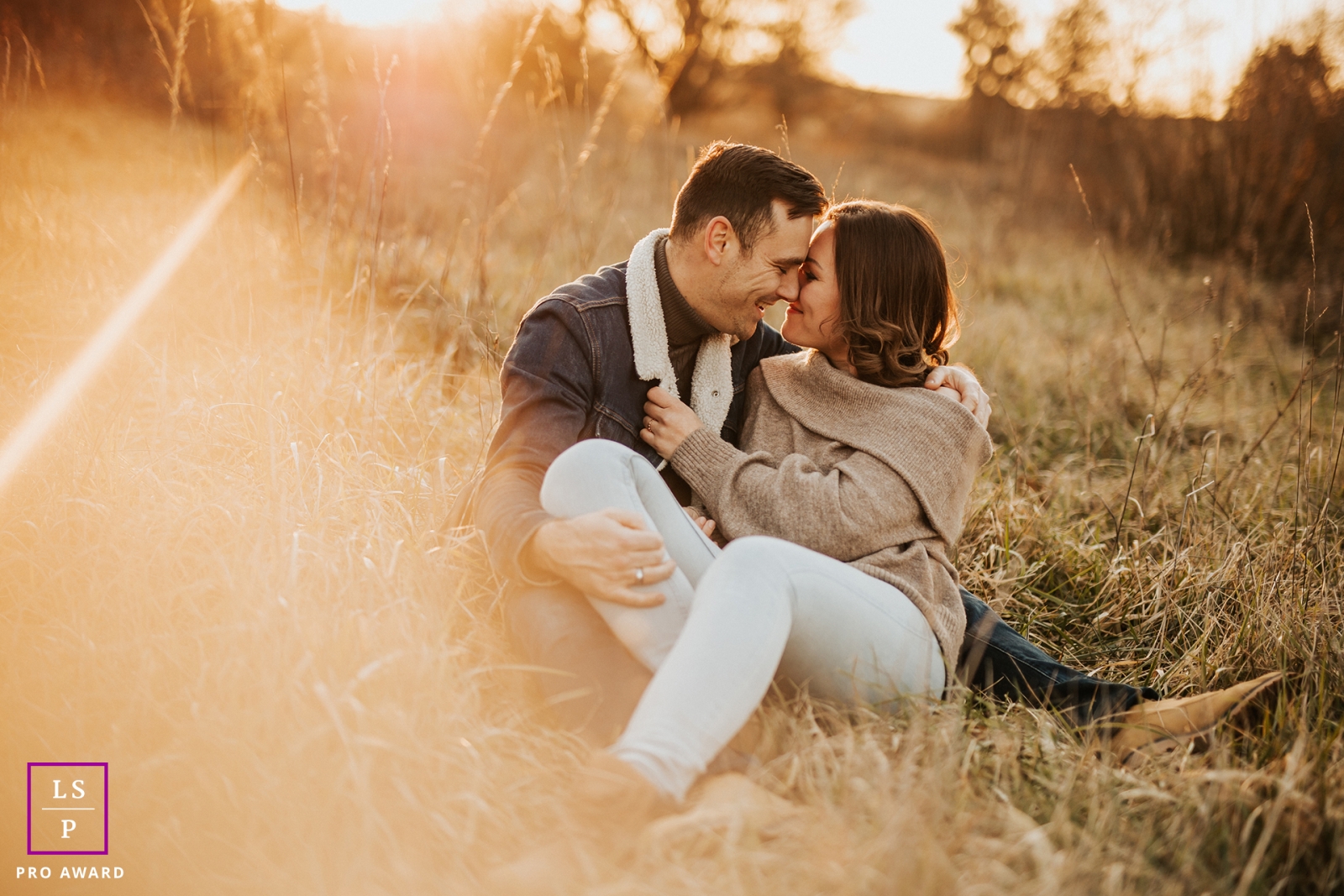 Lovers embrace in the sunshine, surrounded by a picturesque field of dry grass in Legny, France