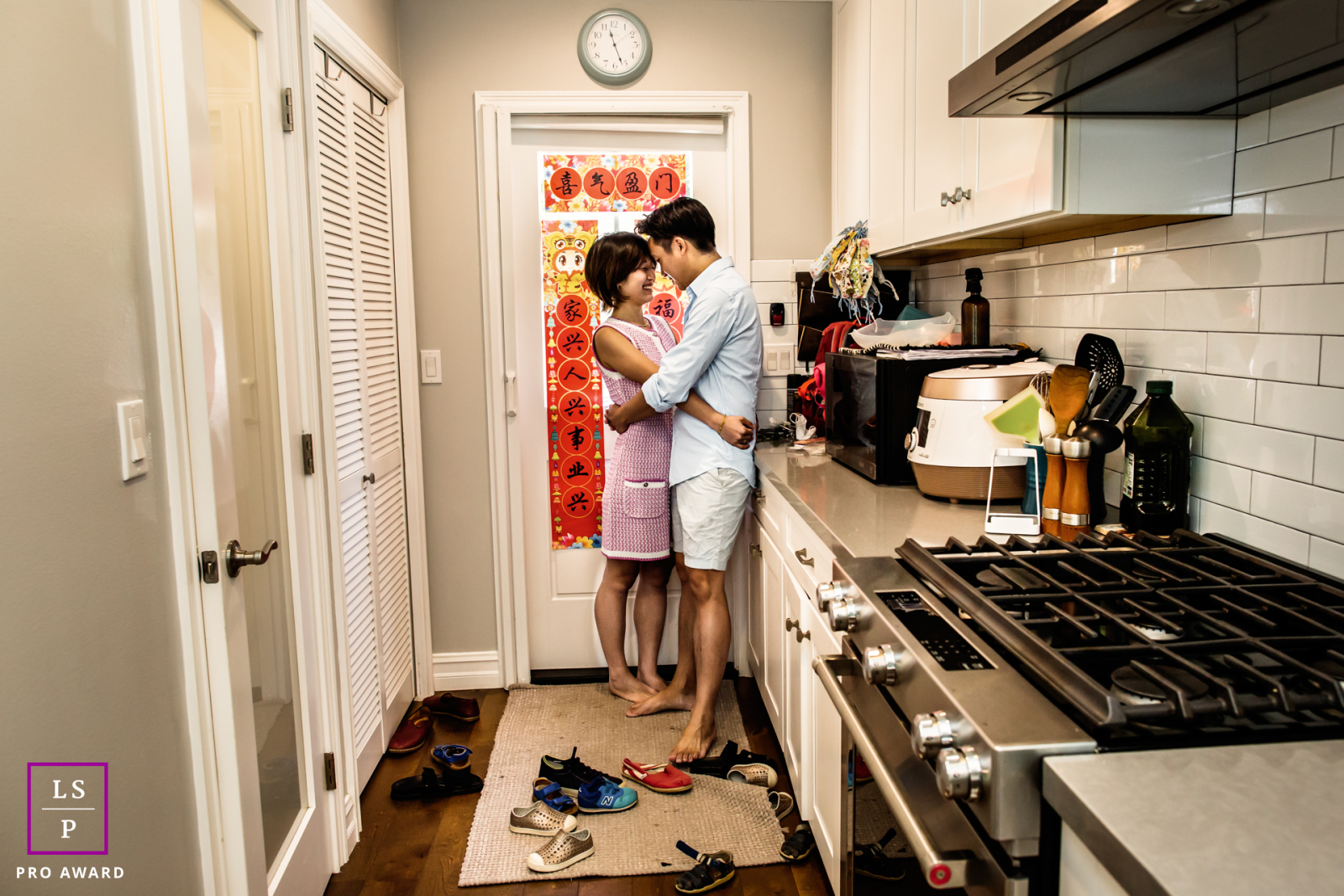 Un portrait intime du style de vie d'un couple dans leur cuisine confortable de Pasadena, souriant avec contentement alors qu'ils profitent d'une étreinte paisible ensemble.