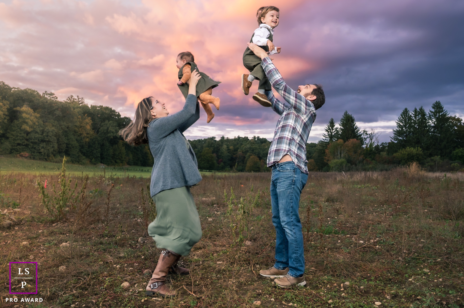 Is this a gravity-defying ritual or just peak parenting? The synchronized lift creates a beautiful cadence against that bruised, Turner-esque sky, celebrating a fleeting moment of pure, sky-high childhood exhilaration.
