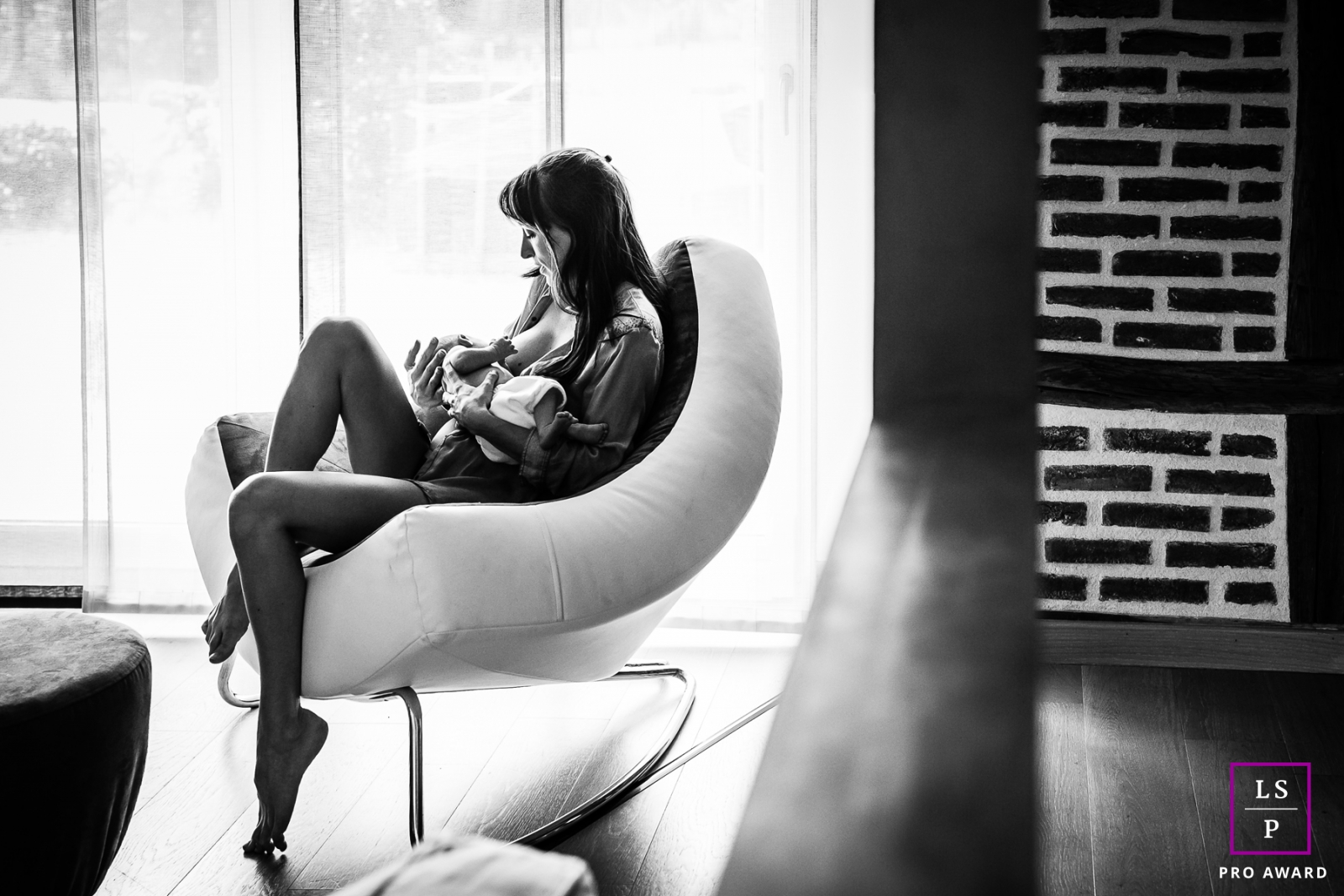 Family Photographer in Bourgogne-Franche-Comte France | Lifestyle Image contains: mother, baby, home, chair, window, black and white