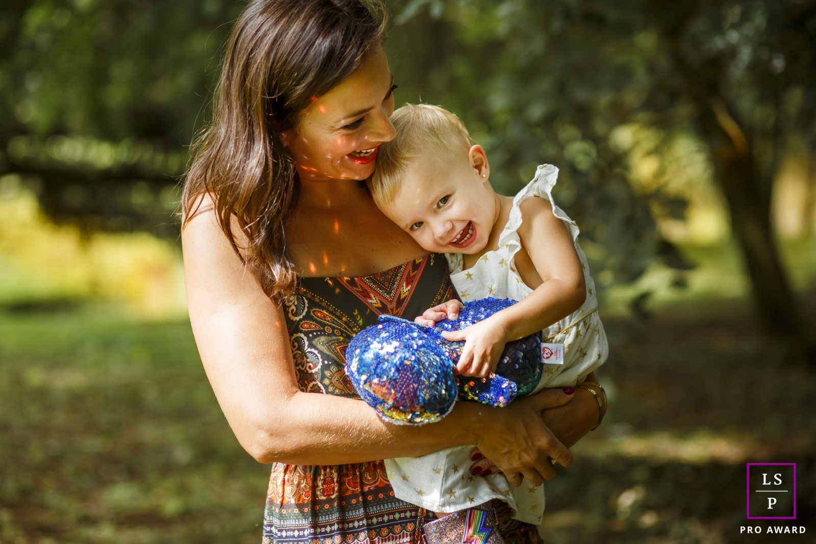 Parana Lifestyle Photographer created this artistic portrait with a Mother holding daughter on her lap in a play in the park