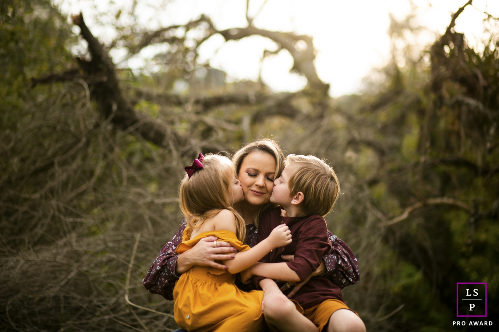 Curitiba Creative Lifestyle Family Portrait image showing A double kiss on mommy with beautiful fall colors