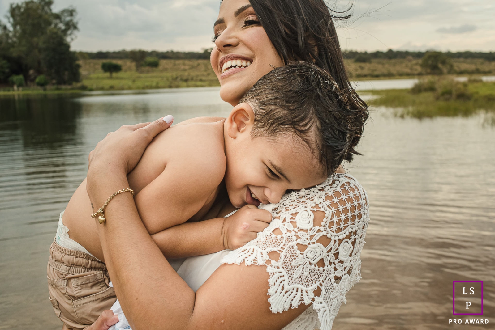 A modern image from Campo Grande to help define lifestyle photography by showing a Mother with a baby on her lap at the water