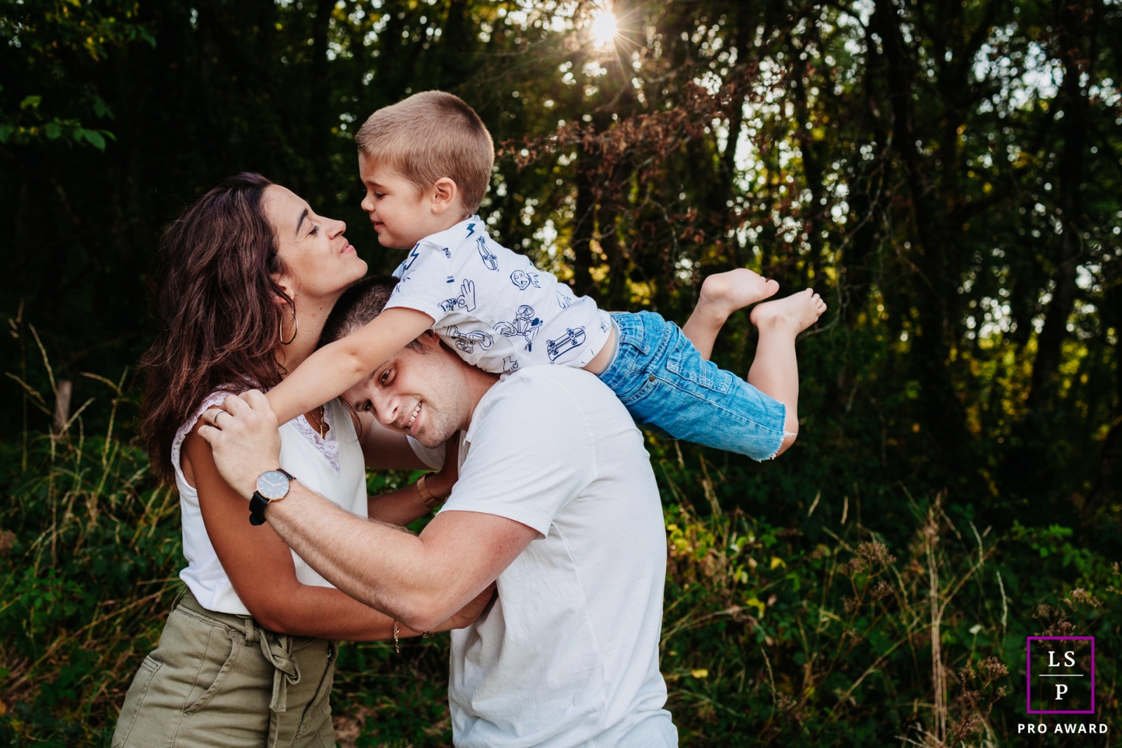A France lifestyle photography shoot portraying a Playing Family together under the tall trees