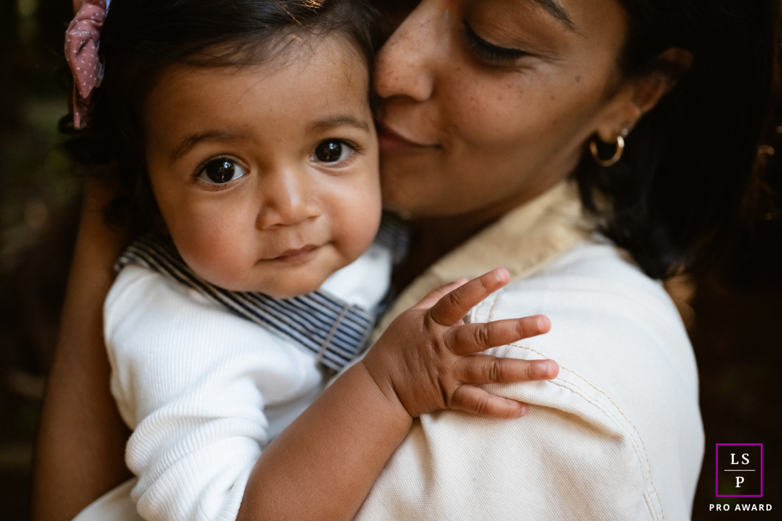 At Roy’s Redwoods in Marin, this toddler looks directly toward the camera while resting safely in her mother’s arms. The close framing and soft affection create a photograph filled with warmth, trust, and beautifully quiet connection.