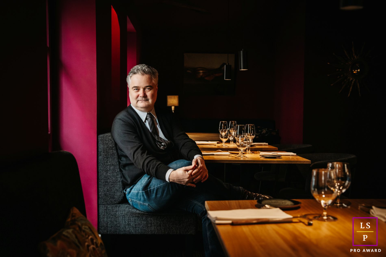 Jérôme Sabatier poses inside the dining room of Bacchanales restaurant and Cave Nil Vino in Lyon before opening. Soft light from windows gently illuminates the elegant, tranquil interior.