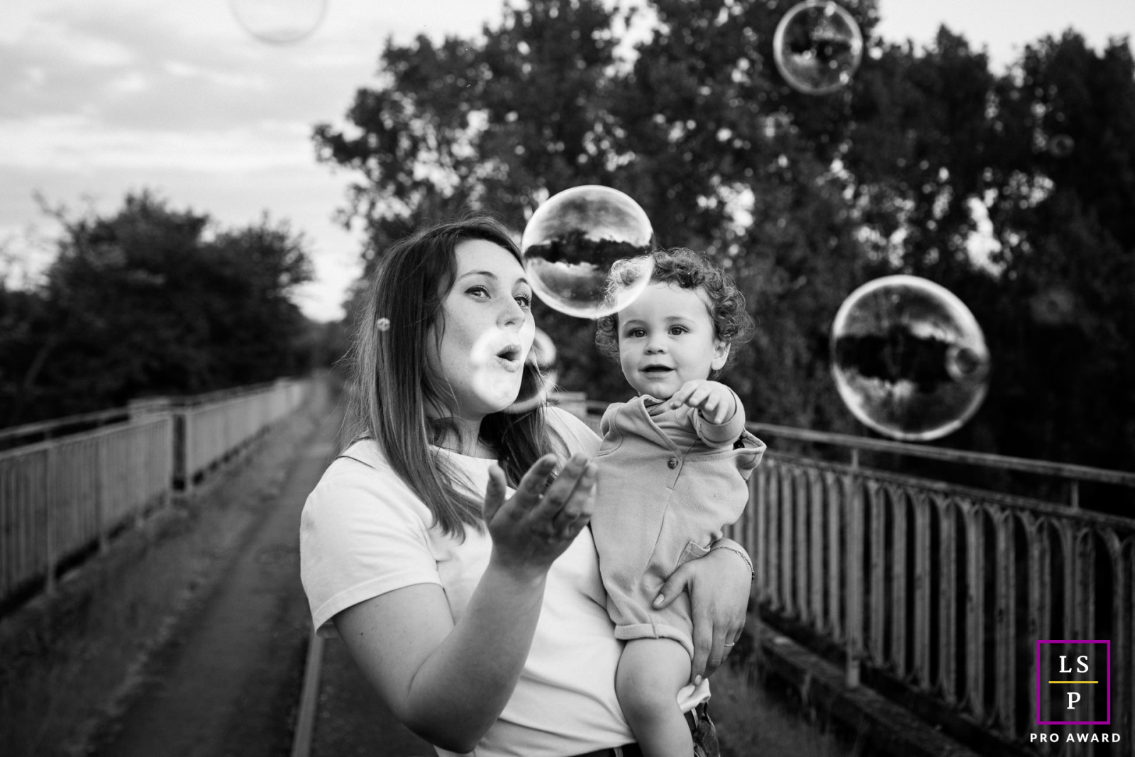 In Haute-Garonne, a mother and son share some fun, playing with bubbles on narrow-gauge rail tracks.