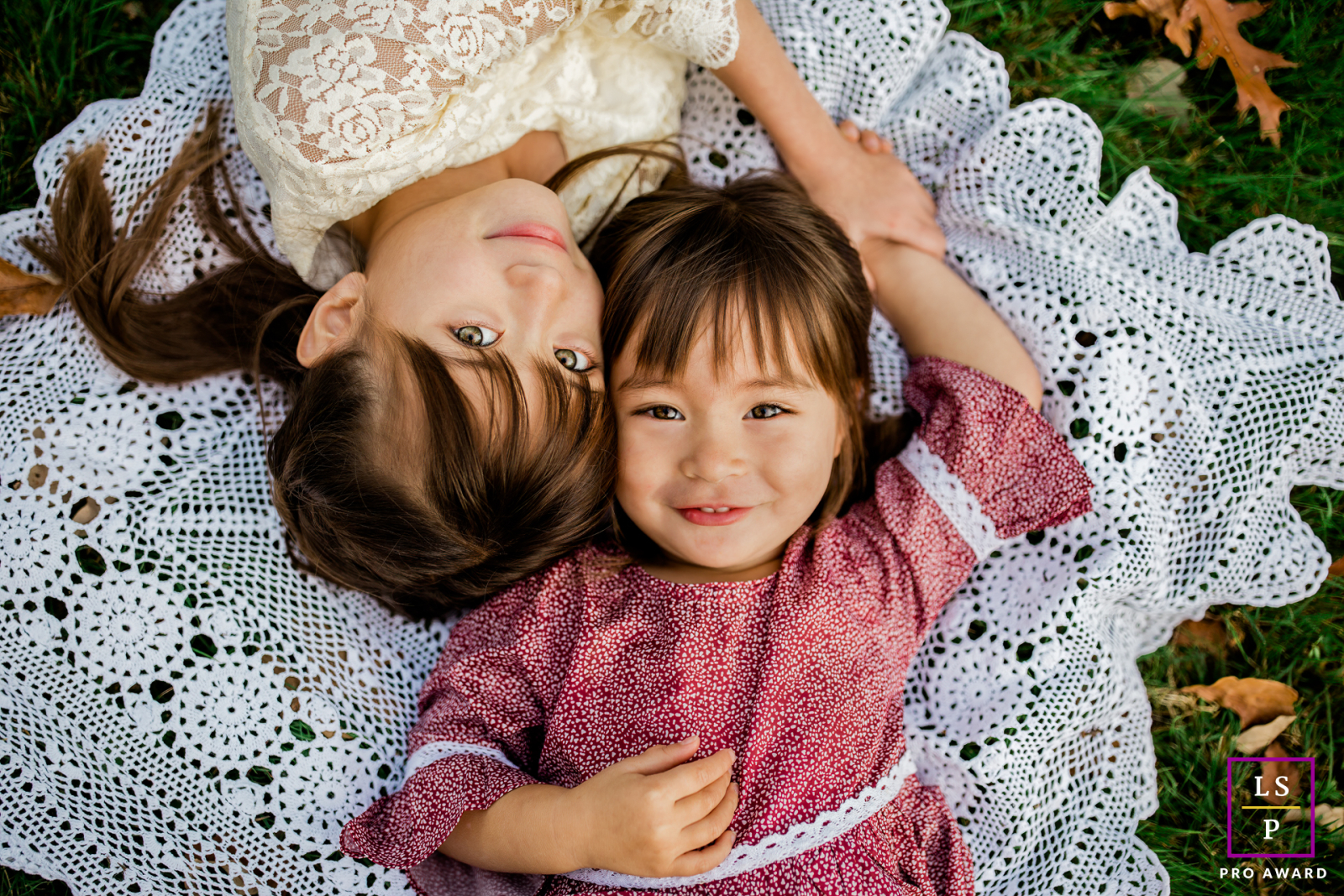On the East Coast, New Jersey, little girls lay on a blanket, looking up and smiling sweetly.
