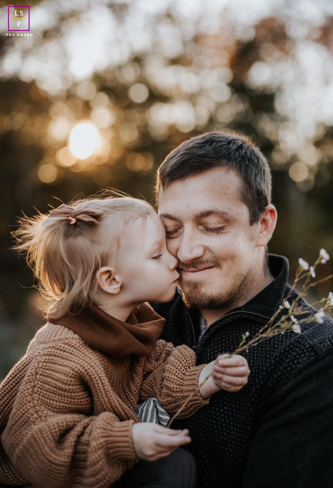 A modern image from an Oregon lifestyle photography session with Father and his girl outside in soft light under trees