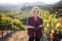Owner of Cache Wine Club stands in a Central Coast, CA vineyard at Avila Beach.