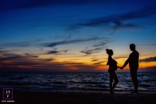 Maternity Lifestyle Photo at sunset by the water under a dramatic sky Key West FL Maternity Lifestyle Photography | Image contains: sunset, pregnancy, portraiture, picture, color, father, mother