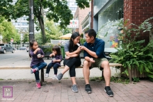 Ontario Family posing for a Lifestyle portrait while eating ice cream just outside their favorite ice cream store in Toronto