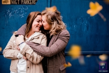 Groningen couple posing for a creative Lifestyle image holding each other while falling leaves are in the foreground