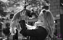 This is a lifestyle image from Utrecht, Netherlands of a woman picking up her dog, her best friend
