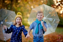 Hampshire, UK family lifestyle portrait session with a brother and sister walking with clear umbrellas Hampshire, UK family lifestyle portrait session with a brother and sister walking with clear umbrellas