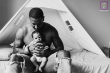 Lifestyle family photography from Sammamish showing a father and a newborn son snuggling in BW