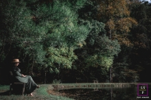 A Tennessee candid image from Knoxville that is defining what a lifestyle portrait is by showing A solo shot in front of a beautiful pond surrounded by trees A Tennessee candid image from Knoxville that is defining what a lifestyle portrait is by showing A solo shot in front of a beautiful pond surrounded by trees