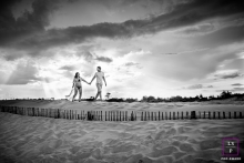 In Herault Occitanie, the couple walk in the sand dune during a BW maternity session