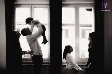 Uma família na Alsácia, na França, desfrutou de uma sessão fotográfica de estilo de vida, com a mãe e o filho de um lado e o pai e o filho do outro, ambos perto das janelas Na Alsácia, na França, uma sessão de fotos de família apresenta duas cenas distintas: a mãe com o filho à direita e o pai com o filho à esquerda, ambos próximos às janelas