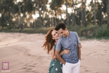 A happy couple from Maceio, Alagoas, smiling while standing on the beach for a lifestyle couple portrait