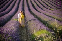 A stunning lifestyle portrait captured in Grignan, France, featuring a couple against a backdrop of vibrant purple lavender fields